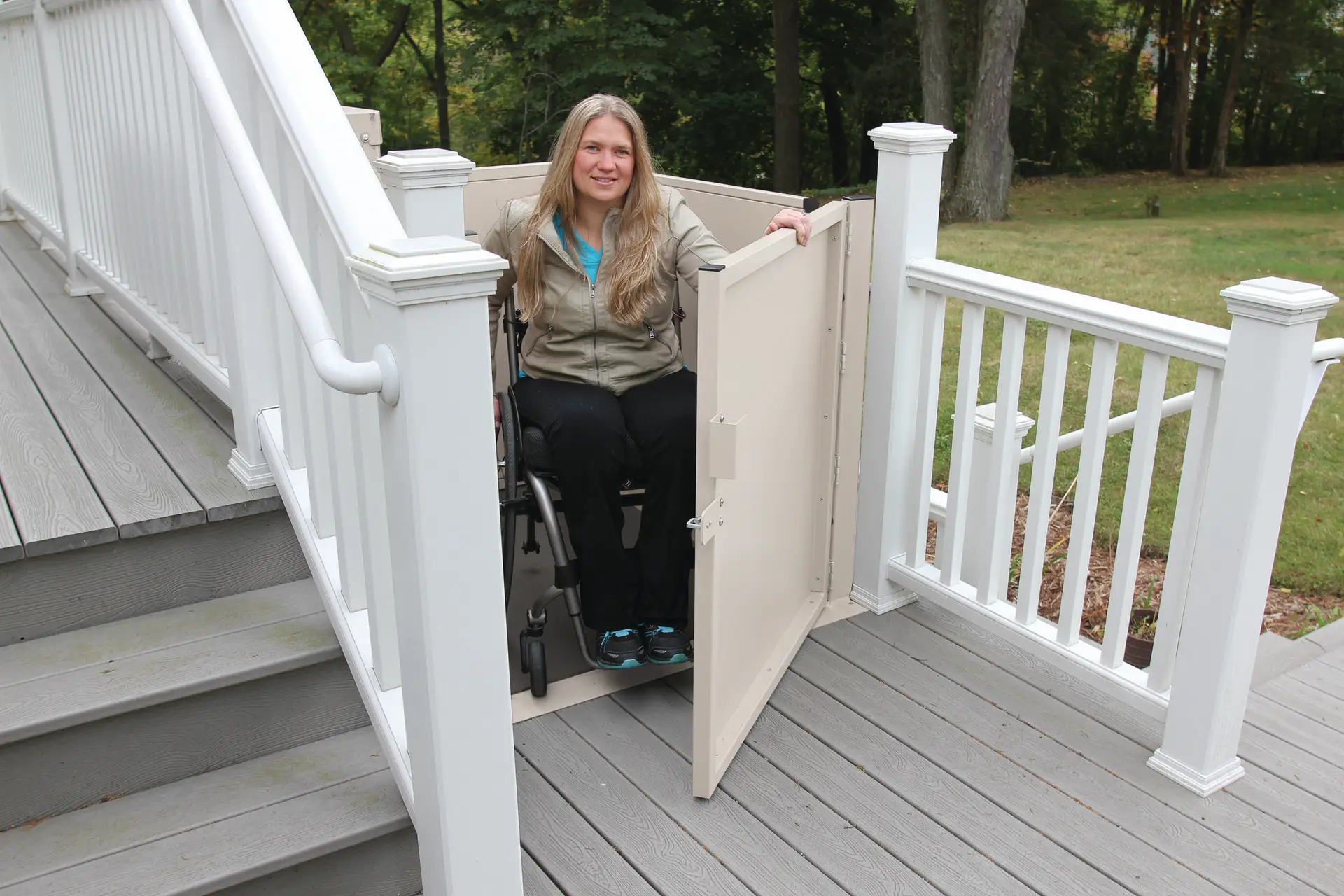 A tall residential vertical platform lift (VPL) installed at the top of a platform, providing safe and accessible vertical transportation for individuals using wheelchairs. The lift features sturdy side rails and a gate for added security.