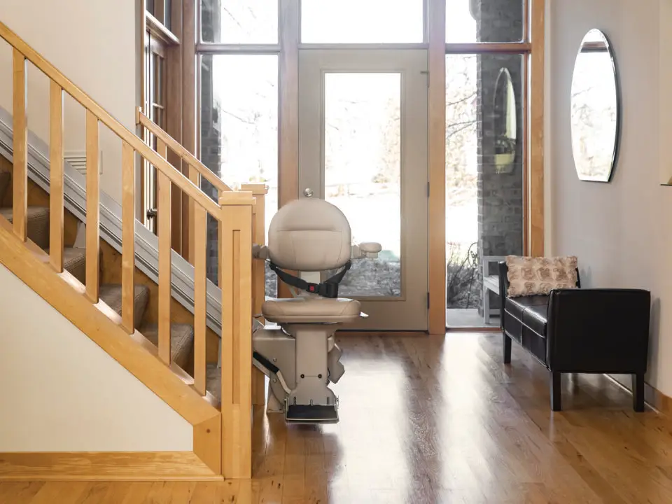 A Bruno Elite stairlift installed on a residential staircase, featuring a comfortable padded seat, armrests, and a smooth rail system. The stairlift is designed for safe and easy mobility along the stairs, providing a reliable solution for individuals with limited mobility.