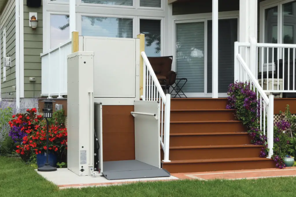 A Bruno platform lift in the lowered position with the gate open, ready for wheelchair access. The platform provides a secure and accessible way for individuals to move between different levels, with the open gate ensuring easy entry and exit.