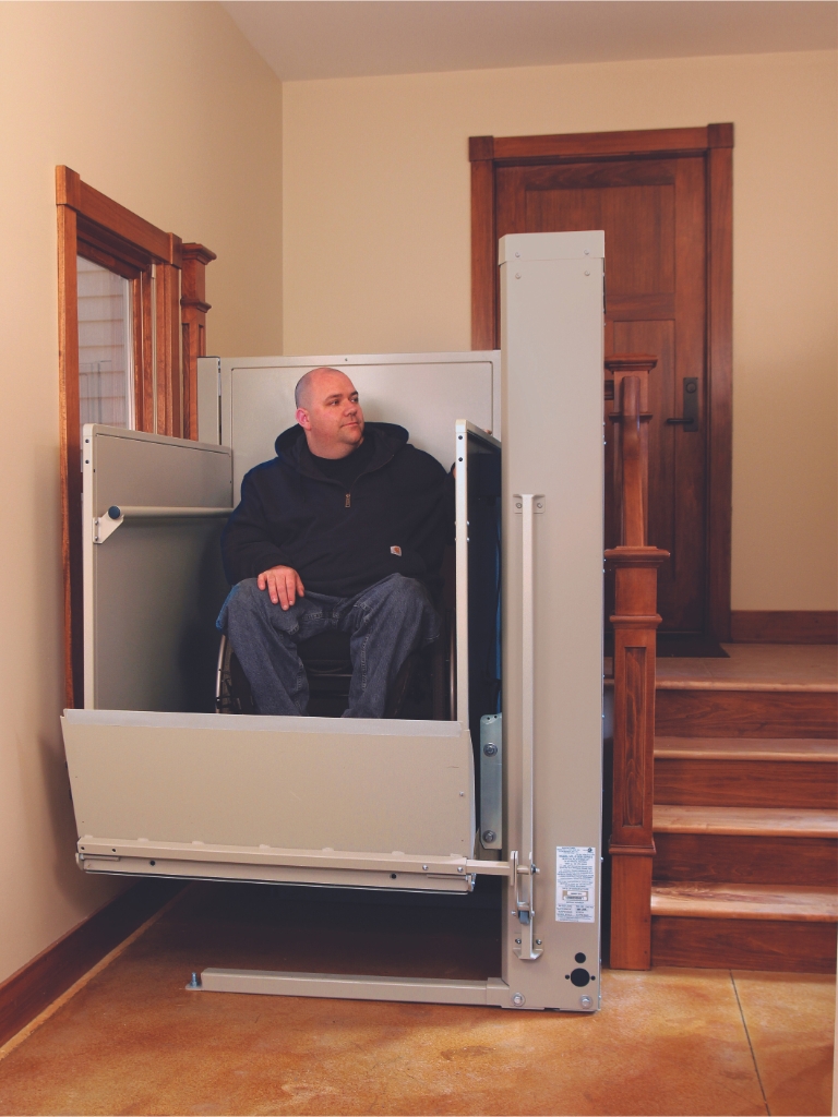 A residential wheelchair lift installed beside a set of stairs, providing an accessible way for individuals in wheelchairs to safely move between different levels of the home.